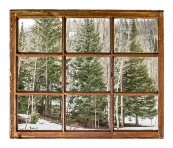 从古老的坚固用脏玻璃砸的窗上看到冬季的树林和小木旅行或度假概念图片
