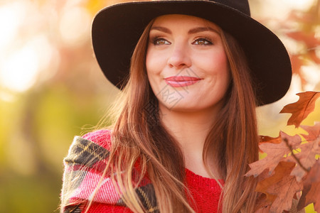 秋天公园的美丽女子秋天公园的迷人微笑年轻女子肖像穿着红色毛衣围巾和黑帽子的时装女孩图片