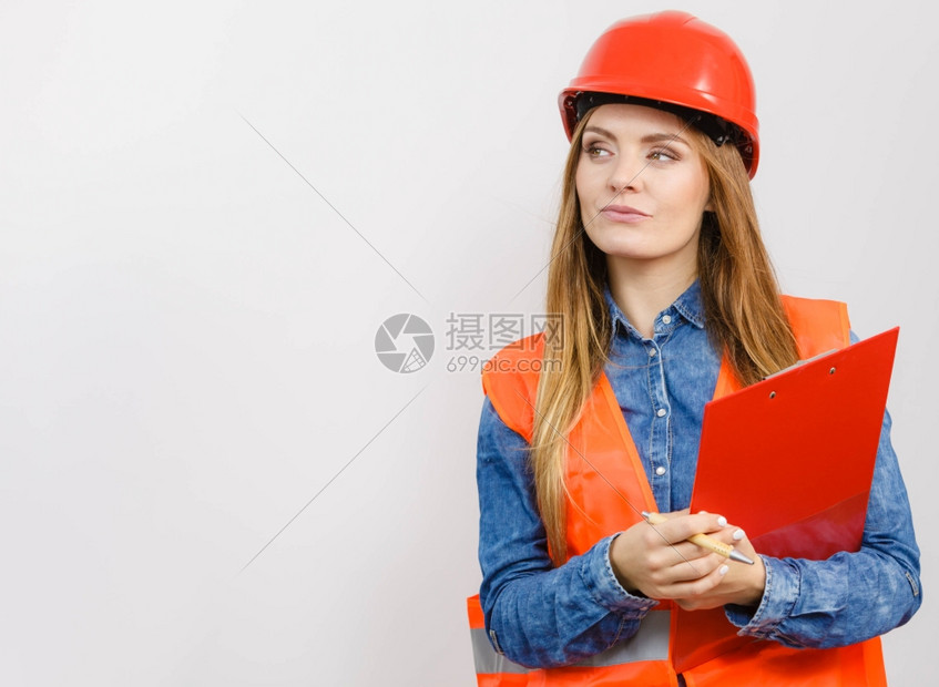 女建筑工人结构程师穿橙色背心红硬头盔的建筑工结构程师持有笔文件垫工业作安全室中图片