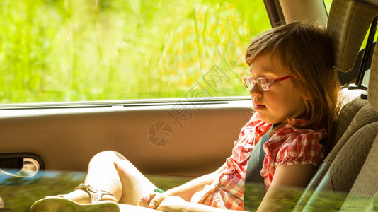 孩子在车里假期旅行带安全戴眼镜的小女孩子坐在车里假期旅行暑安全图片