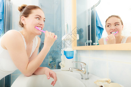 女人刷牙口腔卫生年轻女人刷牙浴室里有刷的女孩图片