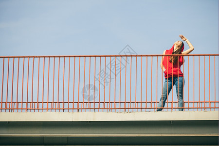 长发少女在城市桥上散步夏天的生活方式很怪异特伦迪运动少年图片