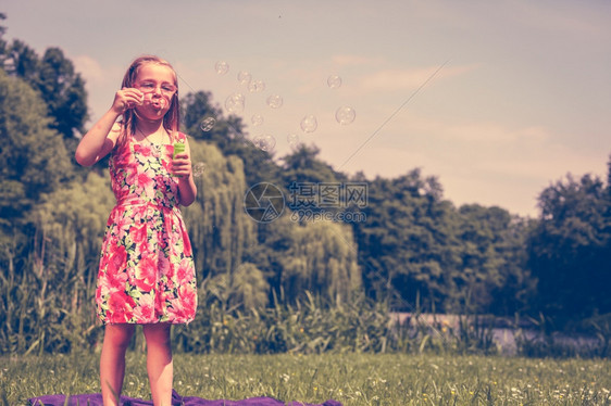 小女孩吹肥皂泡在户外小女孩吹肥皂泡在户外小孩吹肥皂泡在公园玩得开心图片
