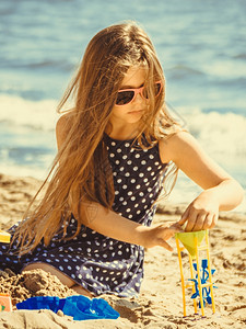有玩具的小女孩在沙滩上玩得开心暑假放松图片