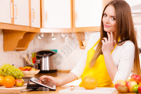厨房的年轻女家庭主妇在餐桌上用平板电脑看食谱健康饮烹饪素饮和技术概念图片