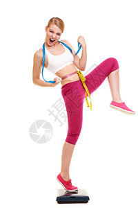 女握紧的拳头测量体重攀升和体重减肥成功快乐的年轻女孩用体重握紧的拳头用胶带测量体积健康的生活方式概念孤立在白色上图片