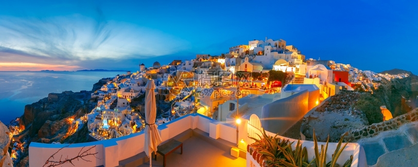 希腊圣托里尼岛的奥亚老城或伊岛白房子和日落时风车图片