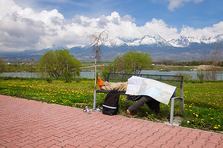 睡在长椅上的人满身是旅行概念图片
