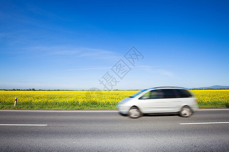 汽车在美丽的黄色田野农村公路上行驶图片