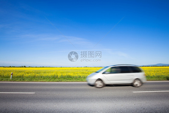 汽车在美丽的黄色田野农村公路上行驶图片