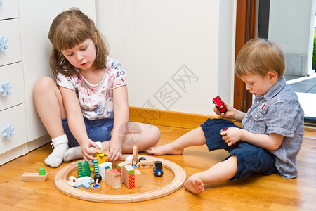 孩子们在房间里玩木制火车图片