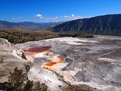 矿藏和岩石在干燥的田地上山丘和蓝天空是背景图片