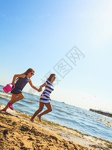 母亲和女儿在沙滩上玩耍夏天乐可爱的女儿和妈玩得开心家人一起在海边玩图片