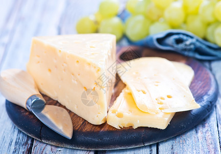 青葡萄和奶酪在切板上背景图片