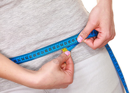 女测量她的臀部体重下降适合的女孩测量她臀部蓝色测量胶带部分女身体被白色隔离图片