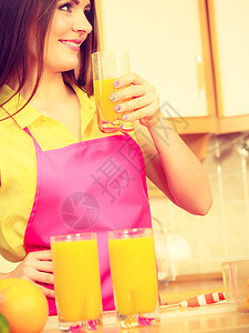 家里厨房的年轻女家庭主妇喝着新鲜自制橙汁饮料健康食素减肥和人的概念图片