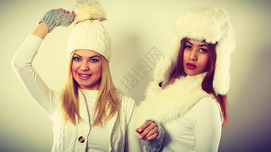 两个穿冬衣的女人时装模特的概念金发和混合种族的穿着温暖衣服的女士图片
