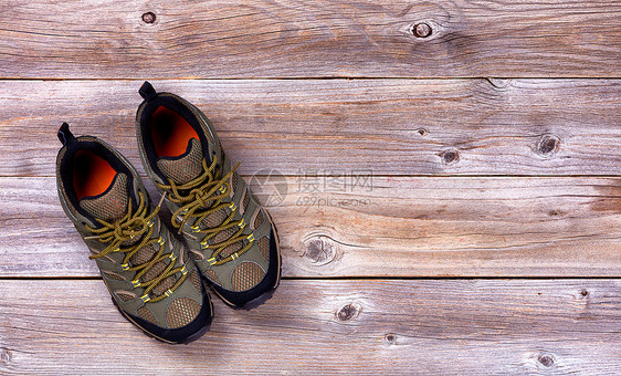 生锈木板上新远足鞋的顶端视图图片