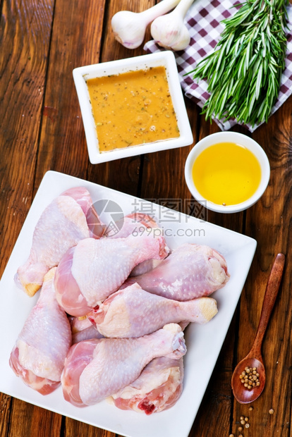 鸡腿盘子上含盐和香料的鸡腿图片