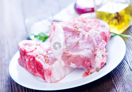 白色餐盘里的生肉排和香料图片