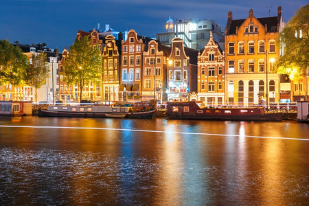 阿姆斯特丹运河荷兰夜间有典型的荷兰码头房屋船和光亮的轨图片
