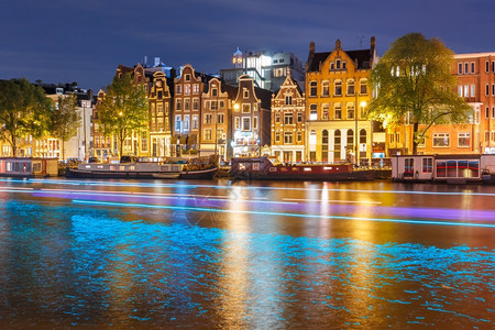 阿姆斯特丹运河荷兰夜间有典型的荷兰码头房屋船和光亮的轨图片