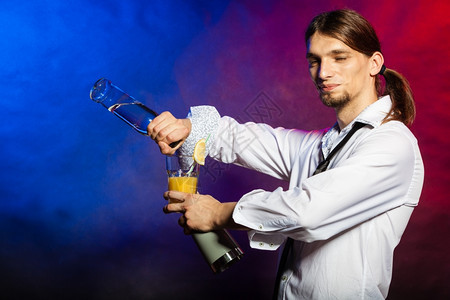 酒吧男招待展示自己的技能弗拉尔酒吧鬼派对的概念年轻男老板做鸡尾酒图片