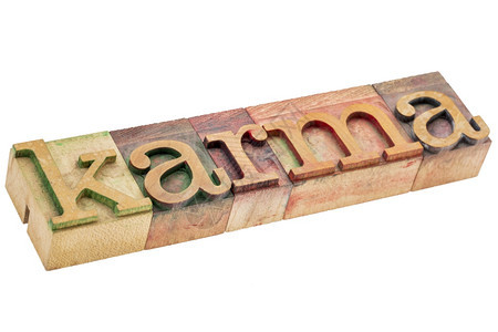 karma单词以彩色墨水染的纸质木型打印块中的孤立文字图片