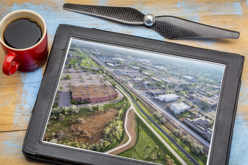 空中摄影概念审查科林斯堡市在数字平板电脑上的照片加一杯咖啡图片