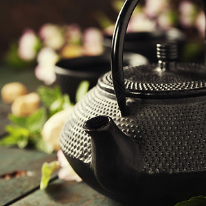 茶叶概念杯和传统壶配有盛开的春树枝图片