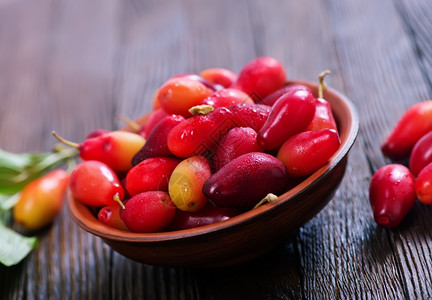 暗红色樱桃玉米樱桃以木本底碗为背景