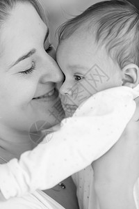 黑色和白紧贴着微笑的母亲抱着她孩子男微笑母亲黑白近身肖像图片