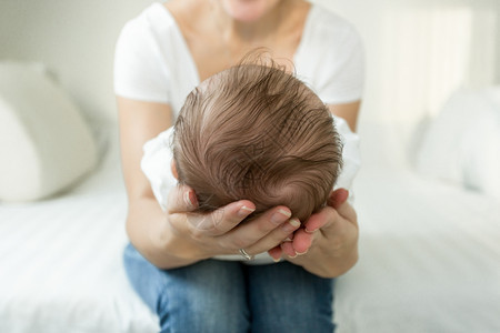 母亲的手握着睡头部近视图像3个月大的婴儿男孩图片