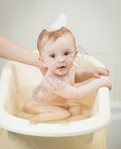 宝宝淋浴可爱的婴儿男孩肖像头上有泡沫洗澡时间背景