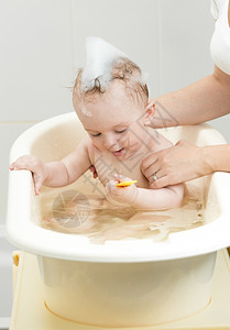 可爱的男孩子洗澡时用泡沫的肖像图片