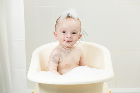 喜笑的男孩坐在浴缸里图片