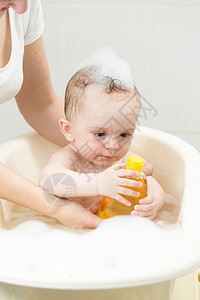 怀着洗浴和发水瓶子的可爱小男孩肖像图片