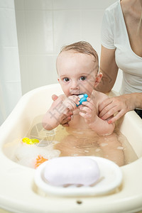 泡澡时玩具的可爱小男孩肖像图片
