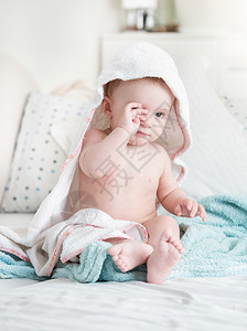 睡着可爱的男孩在洗澡擦眼睛后被毛巾覆盖图片