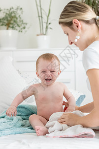 年轻母亲安慰她哭泣的婴儿图片