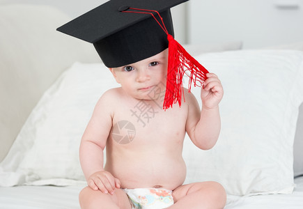 穿着黑色毕业帽子和红帆船的可爱小男孩近身肖像图片