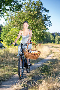美丽的年轻母亲骑着自行车去野餐图片