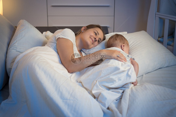 夜欢笑的妈躺在床上与她美丽的宝躺在床上图片