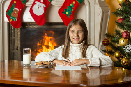 小女孩坐在壁炉边写信图片