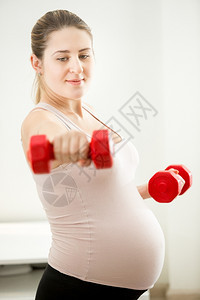 孕妇用哑铃锻炼的近视肖像图片