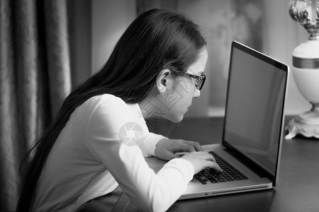 在笔记本电脑上打字失明的少女黑白近身肖像图片