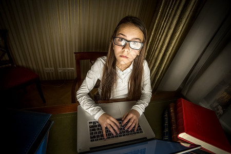电脑怪胎女孩晚上坐在笔记本电脑上的有趣肖像图片