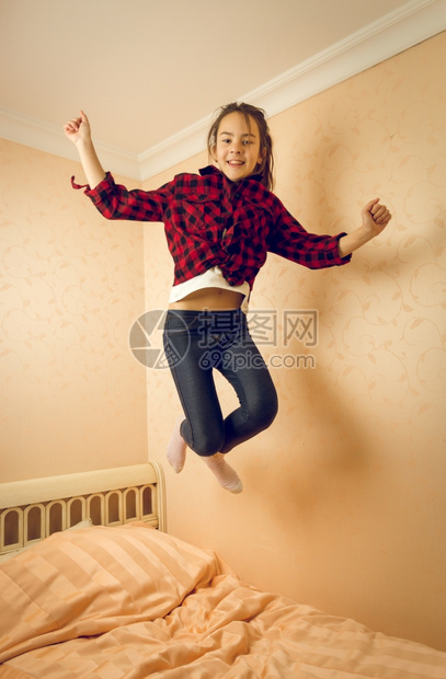 少女在床上跳跃图片