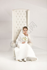 优雅的新娘在豪华椅子上摆姿势图片