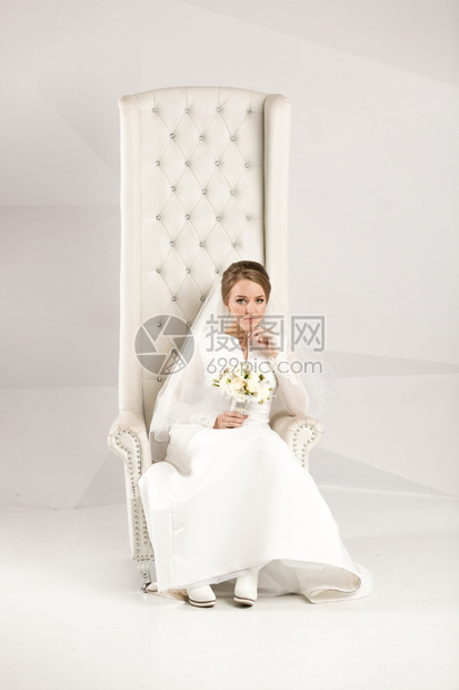 优雅的新娘在豪华椅子上摆姿势图片